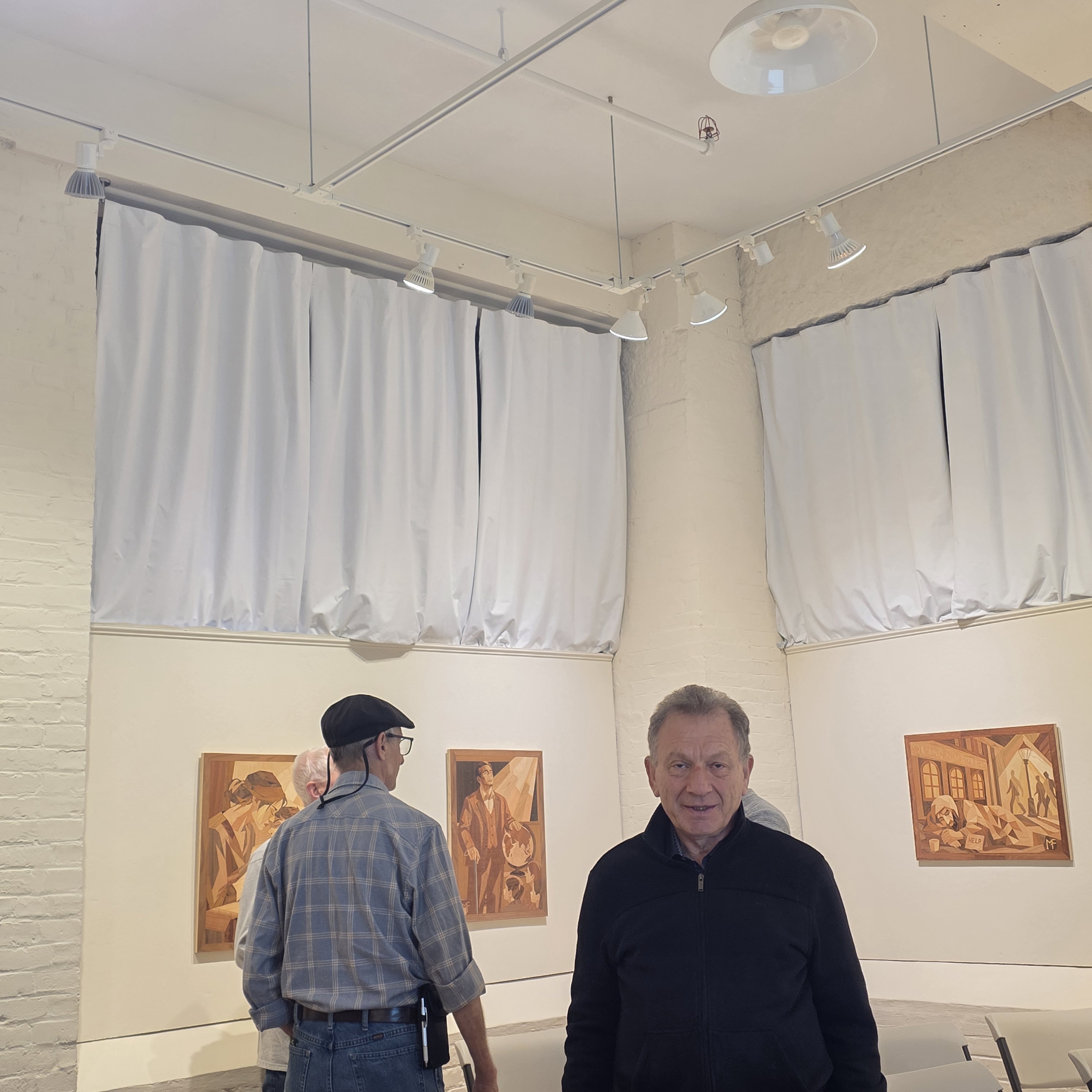 Michael Farro with his marquetry panels on display at the Arts League of Lowell gallery